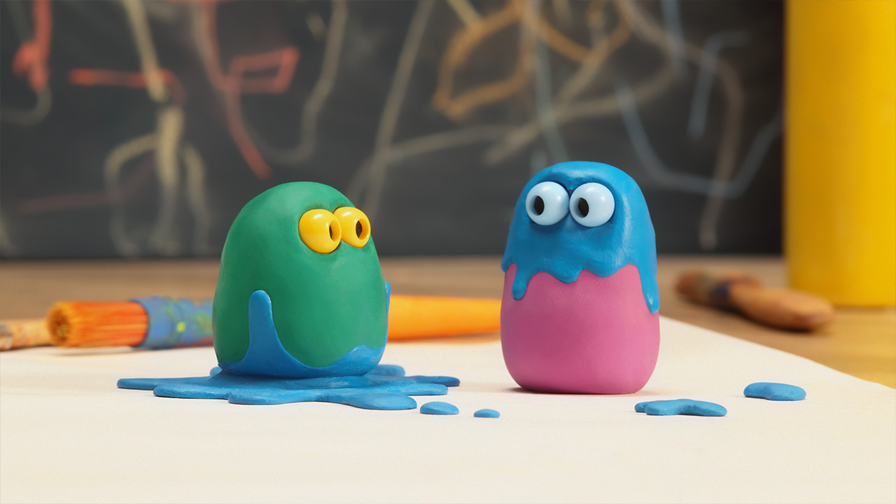 Green and Pink are looking at each other, they are both splattered with blue paint 